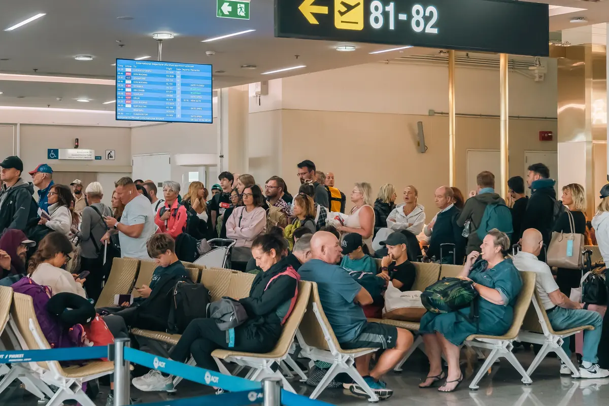 Pasajeros esperando en una sala de embarque llena