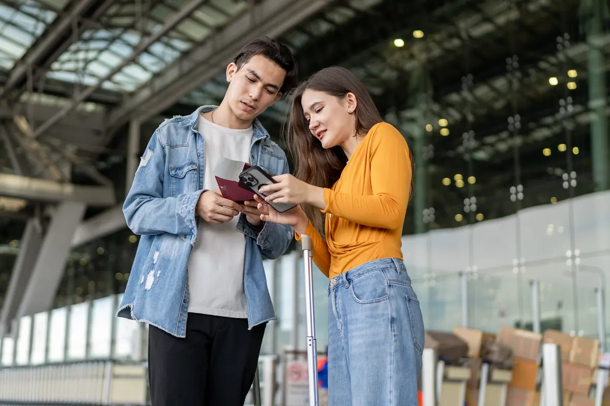 Pareja revisando sus pasaportes en la terminal de un aeropuerto