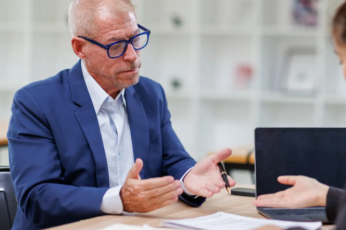 Asesor revisando documentos con un cliente en una oficina
