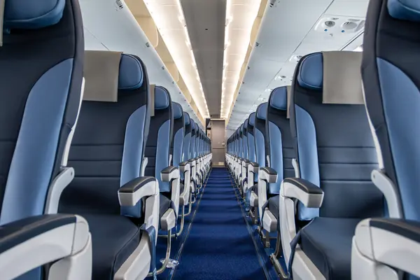 Pasillo y filas de asientos de la cabina de un avión