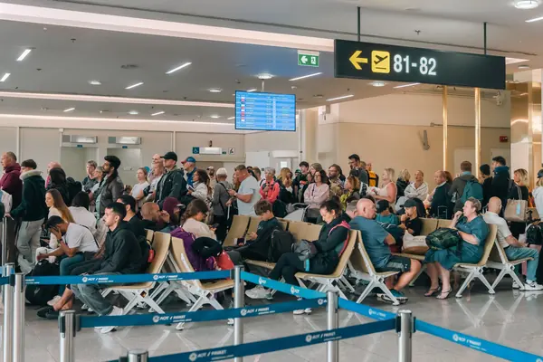 Sala de embarque llena de pasajeros esperando su vuelo